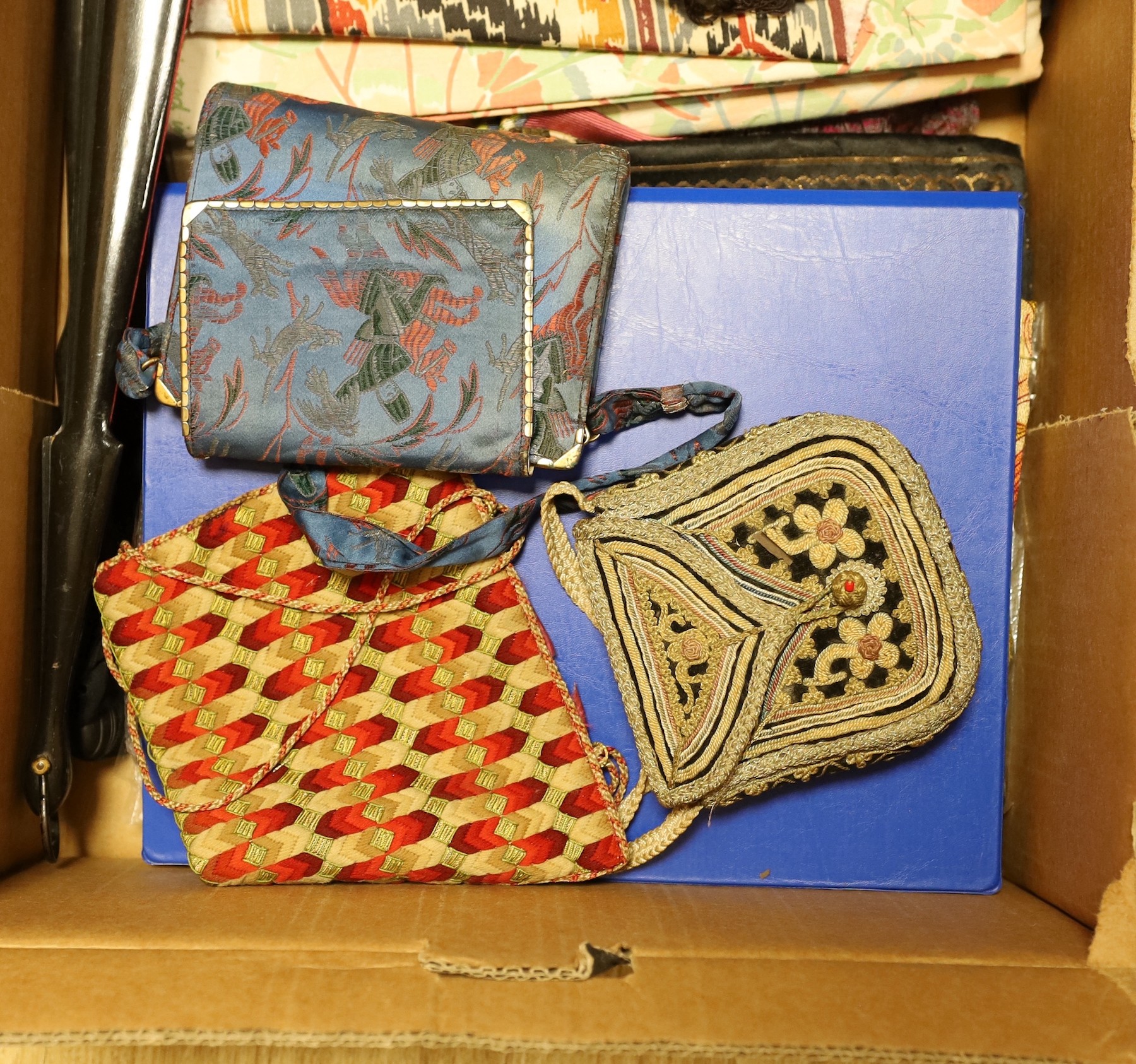 A collection of various fabric samples, fabric bags and a pink parasole